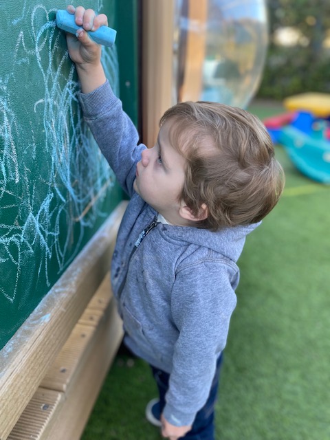 A child drawing on the chalkboard.